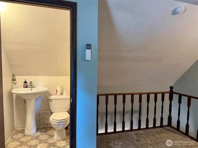 a bathroom with a toilet a sink and a window