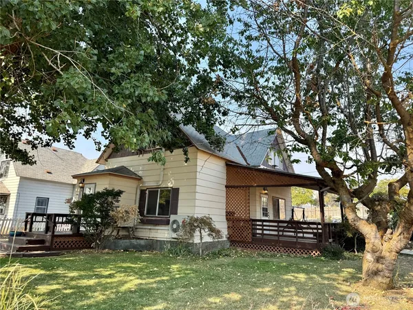 a front view of house with yard outdoor seating and lots of trees