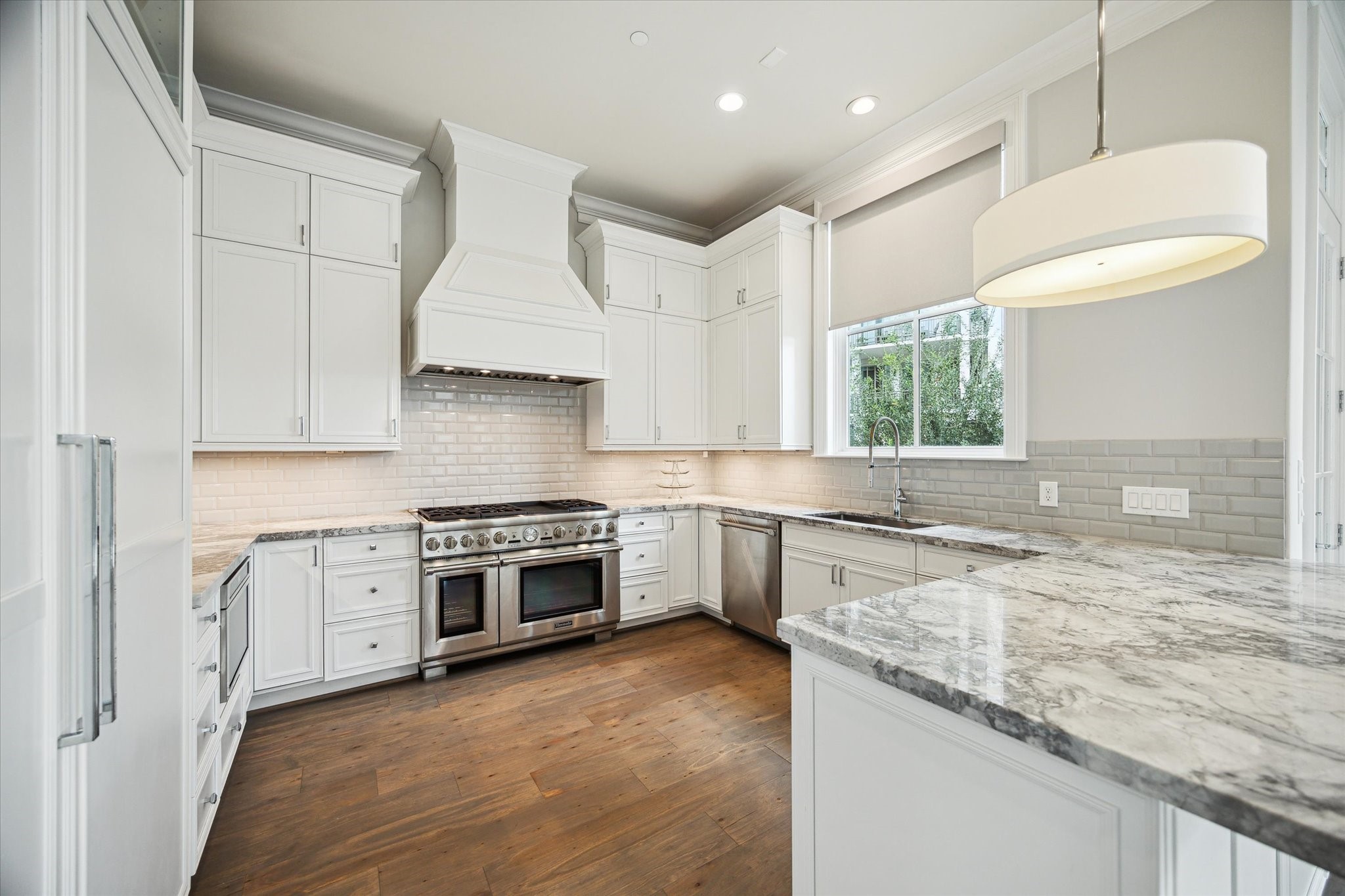 2336 Welch Street Houston, TX 77019 - Photo 20 of 39 a kitchen with granite countertop stainless steel appliances a stove sink and cabinets