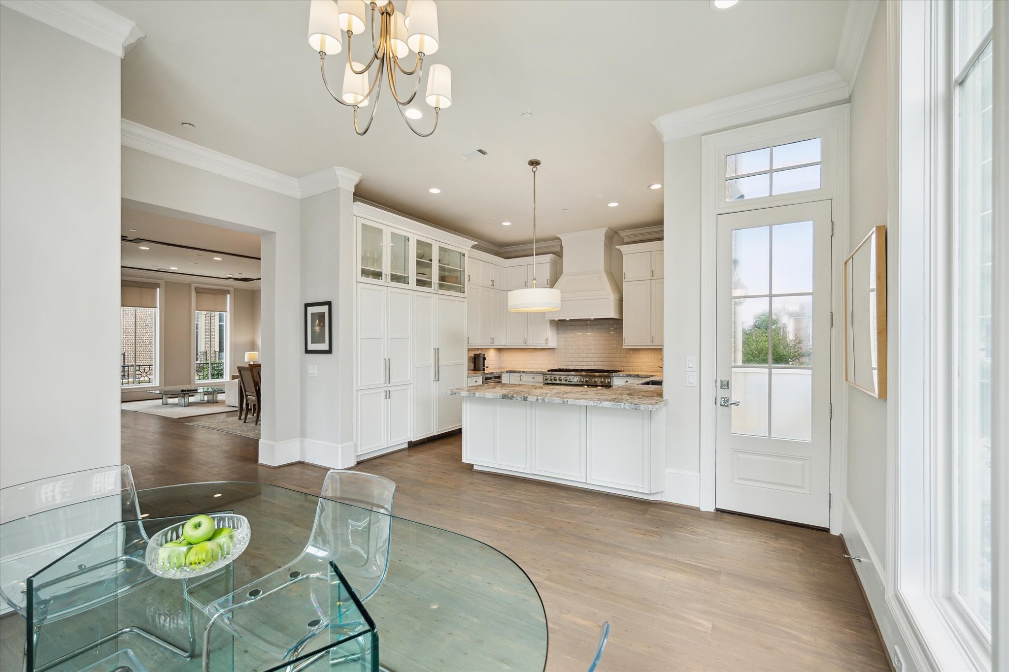 2336 Welch Street Houston, TX 77019 - Photo 23 of 39 a kitchen with stainless steel appliances kitchen island granite countertop a stove a refrigerator a sink a dining table and chairs with wooden floor
