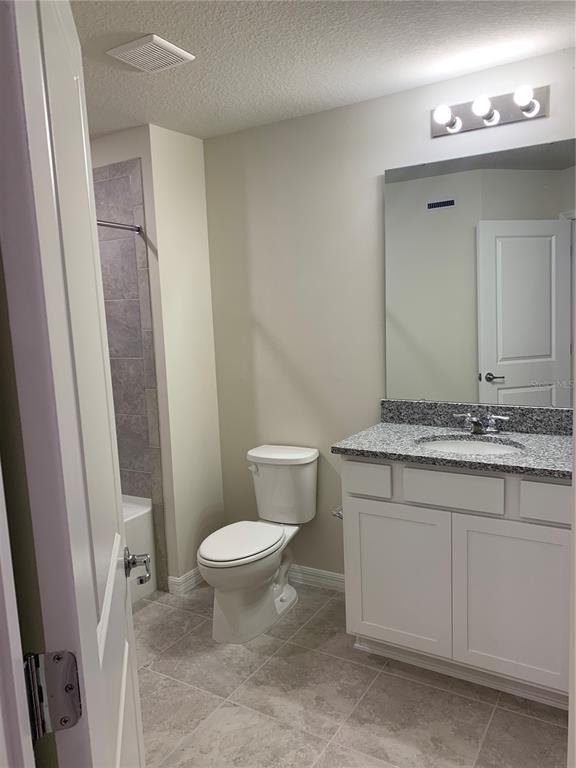 2563 Buena View Road Kissimmee, FL 34746 - Photo 13 of 15 a bathroom with a granite countertop sink toilet and a mirror