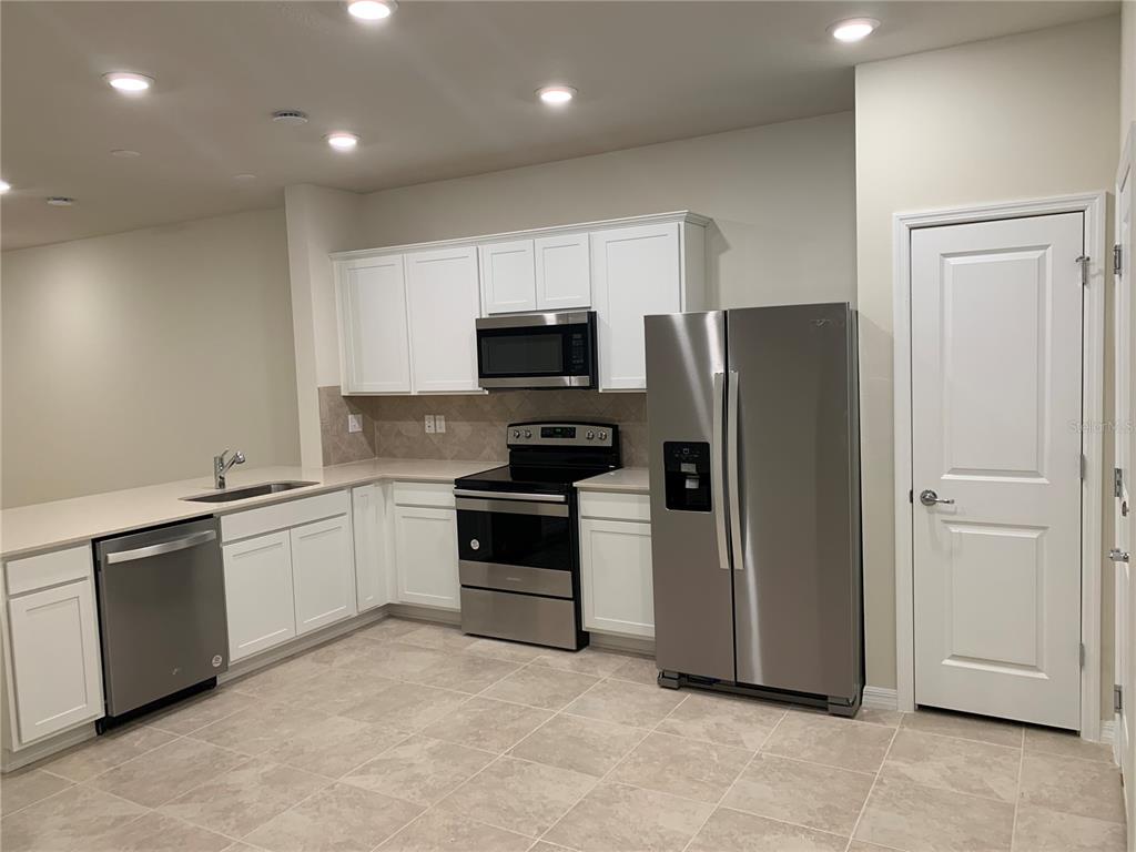 2563 Buena View Road Kissimmee, FL 34746 - Photo 2 of 15 a kitchen with a refrigerator stove and microwave