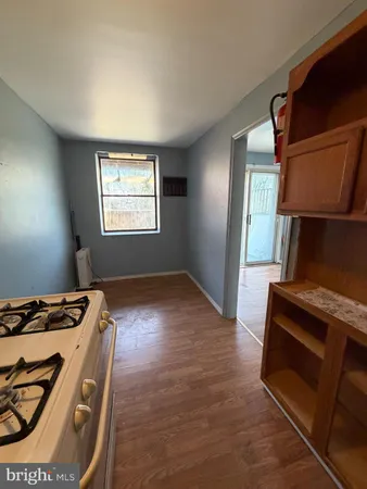 a view of kitchen with stove and cabinets