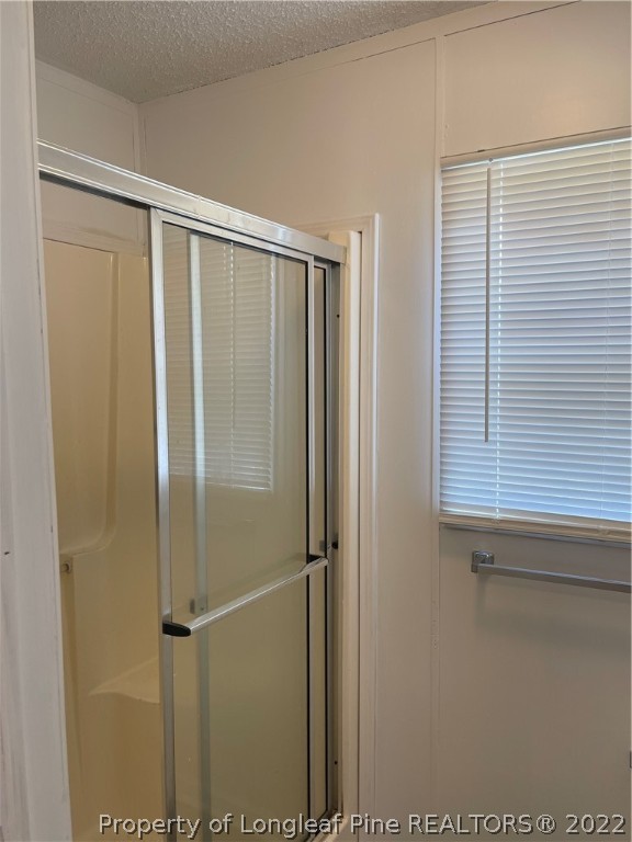 3915 Alamac Road Lumberton, NC 28358 - Photo 12 of 18 a bathroom with a glass shower door