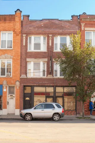 a front view of a residential apartment building with a parking space