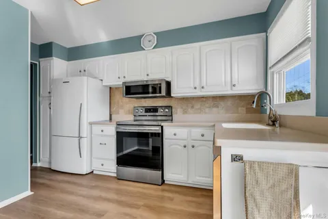 a kitchen with stainless steel appliances a stove a sink and a refrigerator