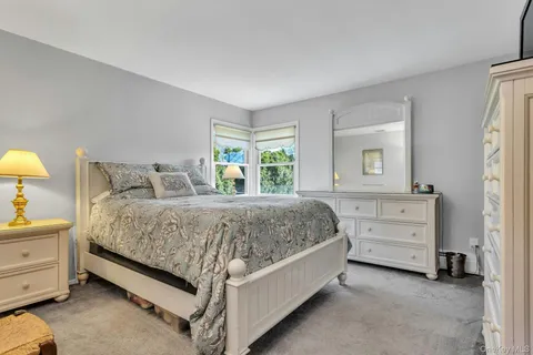 a spacious bedroom with a bed and a dresser