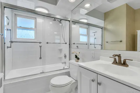 a bathroom with a sink a mirror toilet and bathtub