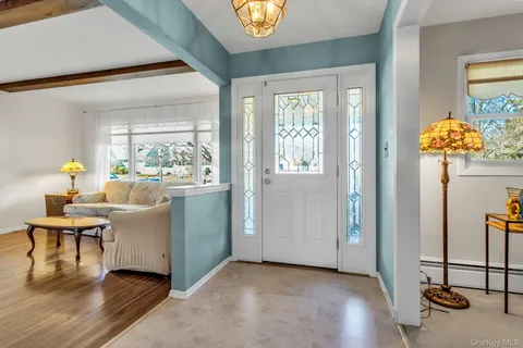 a living room with furniture a chandelier and a window