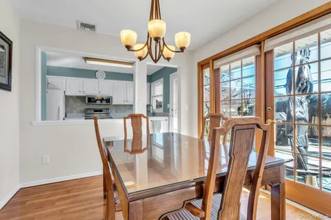 a dining room filled chandelier and wooden floor