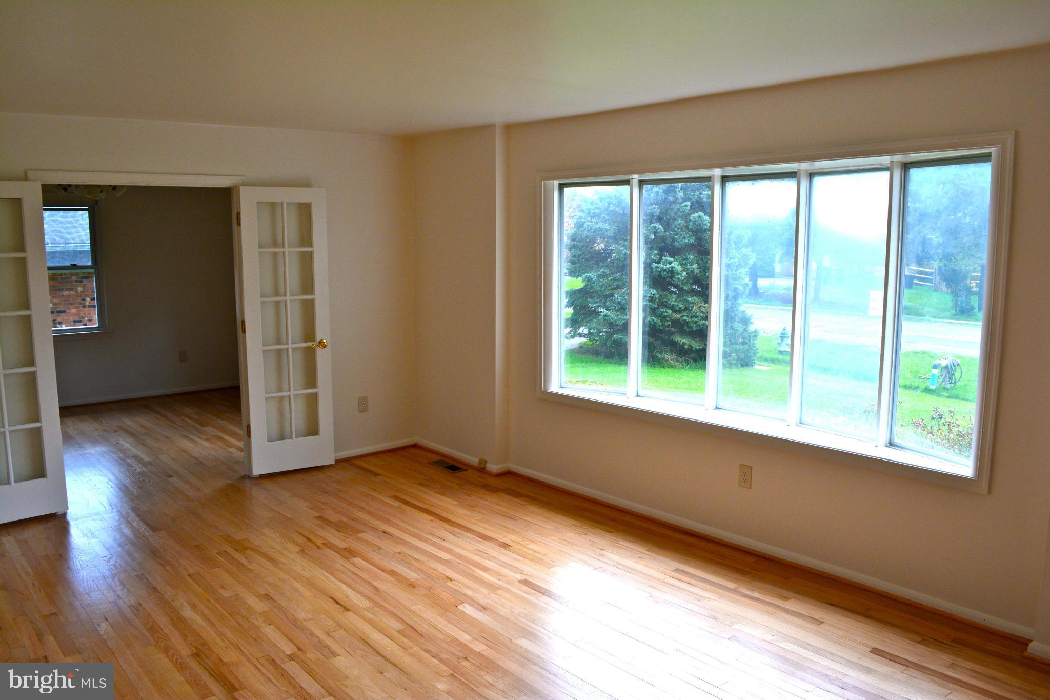 19456 Olney Mill Road Olney, MD 20832 - Photo 4 of 30 a view of an empty room with wooden floor and a window
