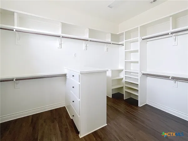 a view of walk in closet with empty racks