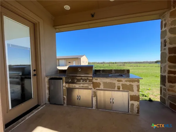 a view of kitchen with stainless steel appliances granite countertop a stove and a microwave