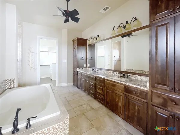 a spacious bathroom with a double vanity sink a mirror and shower