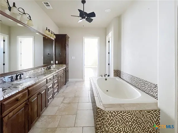 a large bathroom with a tub sink shower and mirror