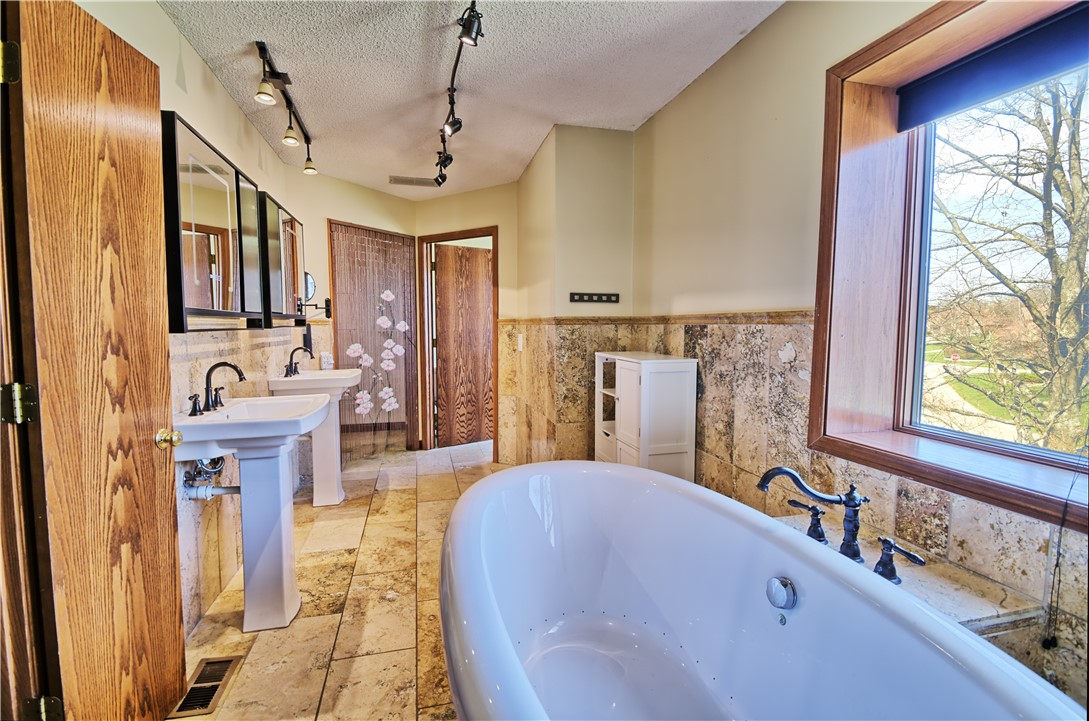 8711 Nicole Lane Springboro, OH 45066 - Photo 44 of 87 Luxurious bathroom with dual pedestal sinks and a freestanding soaking tub.