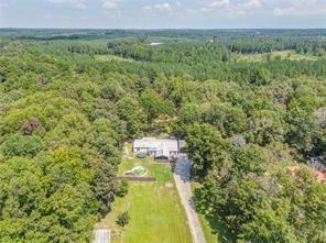 a aerial view of a residential houses with outdoor space and trees