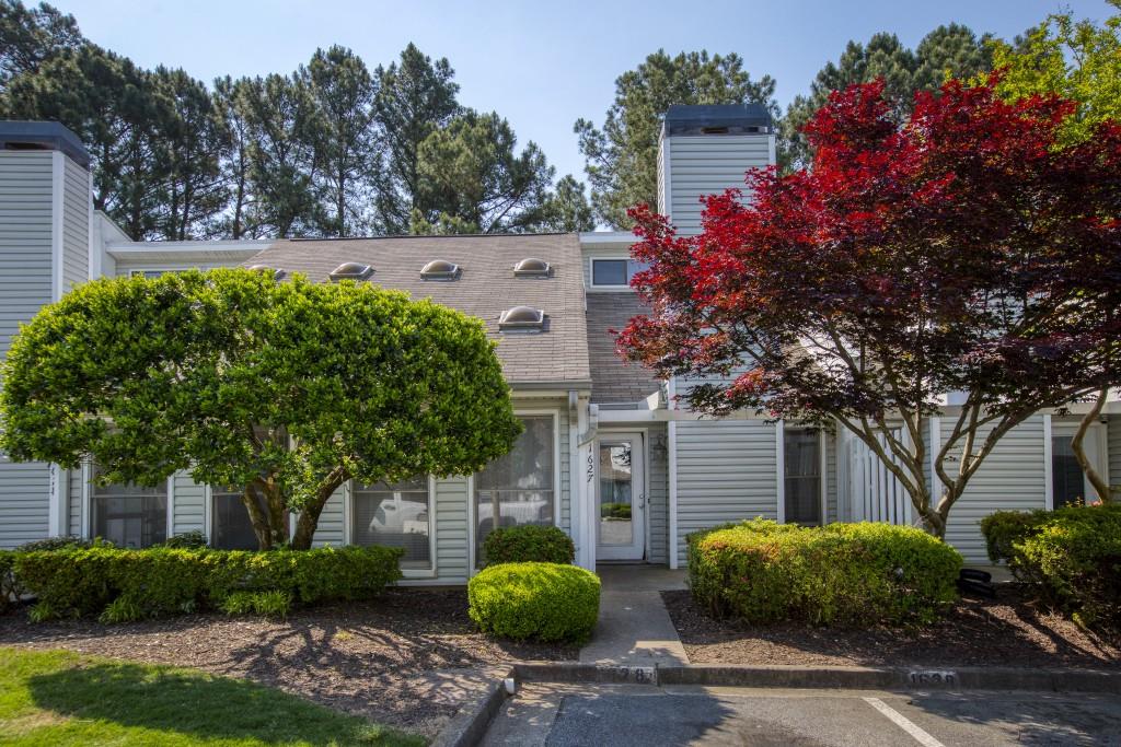a front view of house with a garden