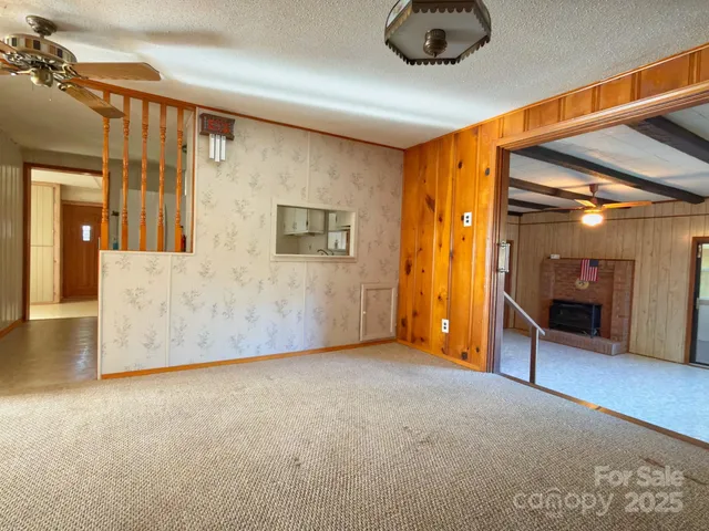 a view of an empty room with a fireplace and a window