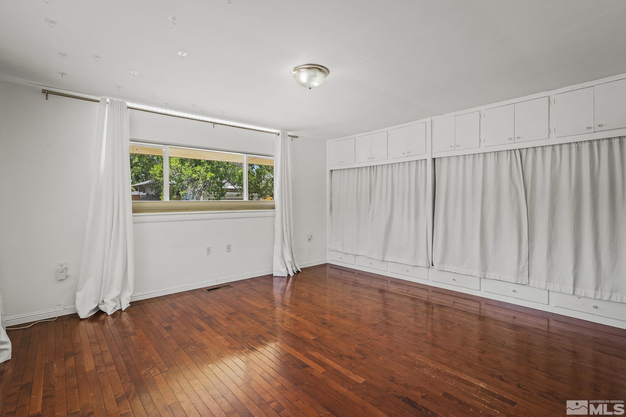 1165 Mt Rose Street Reno, NV 89509 - Photo 7 of 12 an empty room with wooden floor and windows