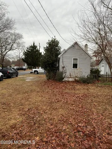 a backyard of a house with large trees and barbeque oven