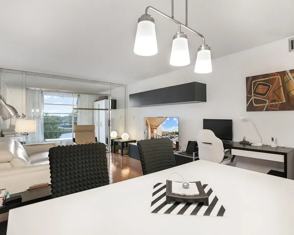 a living room with furniture a large window and a chandelier