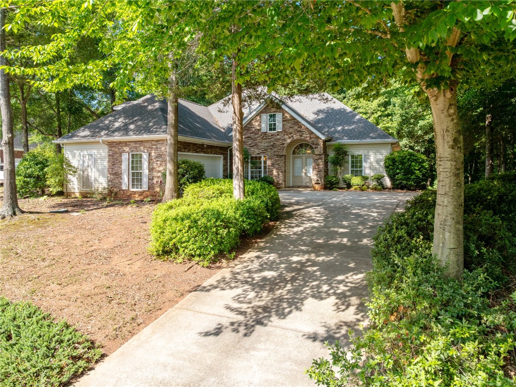 108 Winterbrook Circle Seneca, SC 29678 - Photo 2 of 40 A graceful home framed by mature trees, presenting a charming facade with a welcoming driveway.