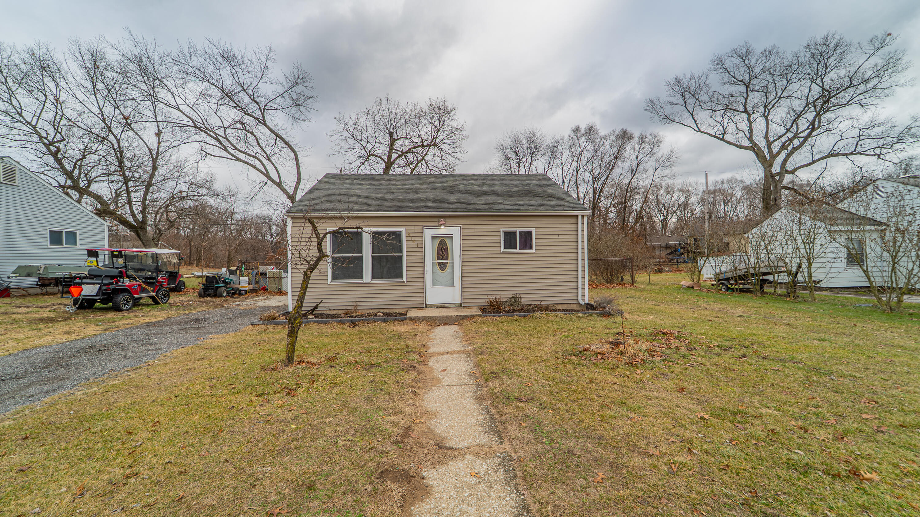 a view of a yard in front of a house with a large tree