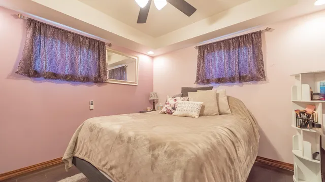 a bedroom with a bed and a dresser with wooden floor