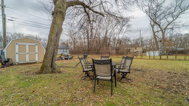 a view of a backyard with table and chairs and garden