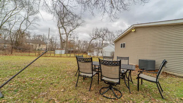 a backyard of a house with table and chairs