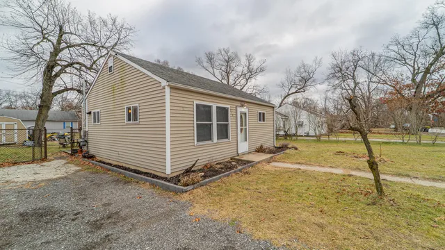 a view of a house with backyard and trees