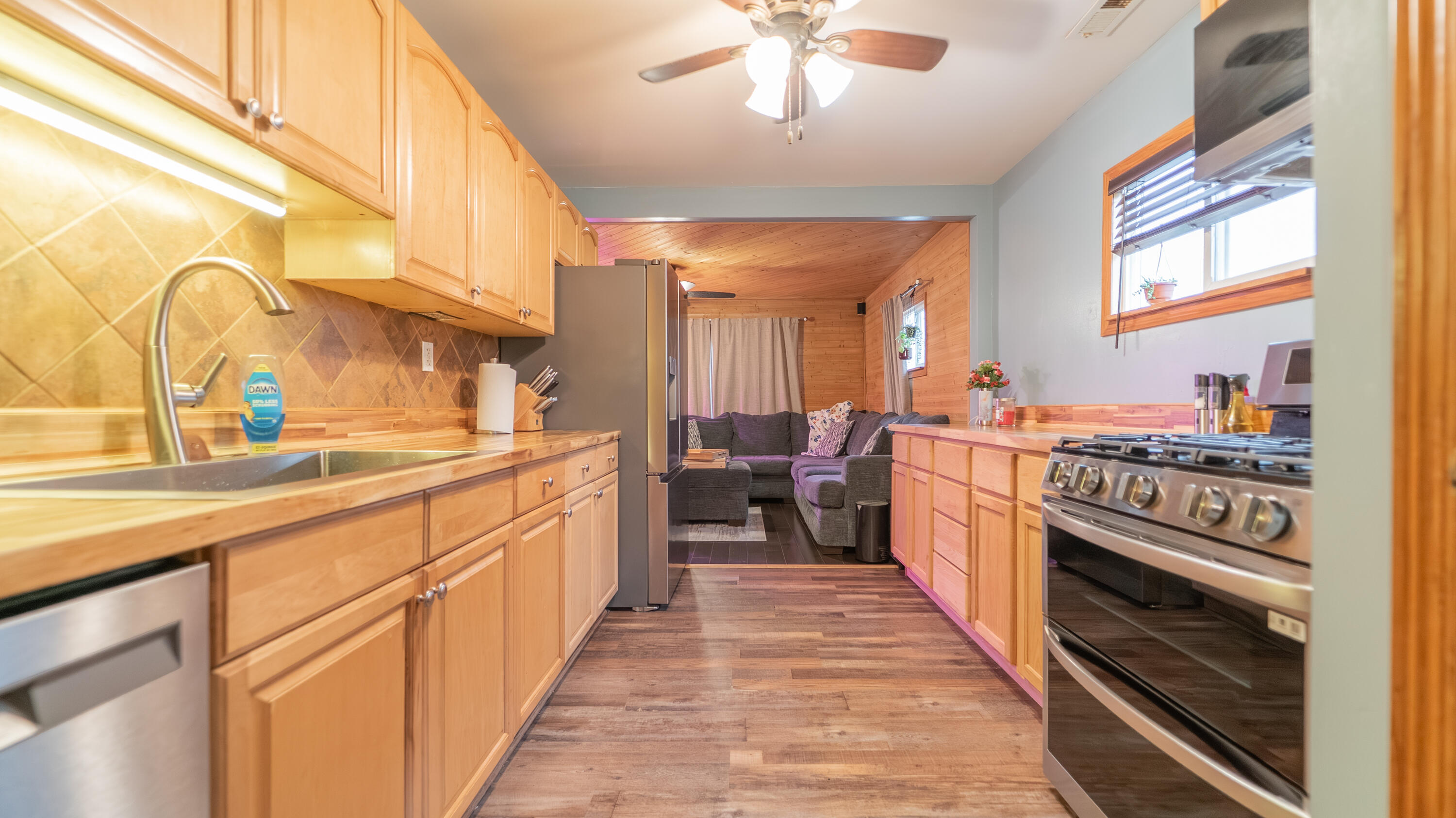 3161 Pulaski Street Hobart, IN 46342 - Photo 6 of 22 a view of a kitchen with kitchen island a stove a sink a chimney wooden floor and cabinets