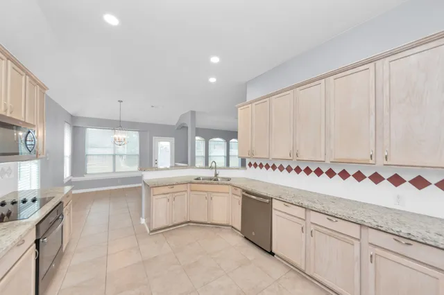 a large white kitchen with a sink and cabinets