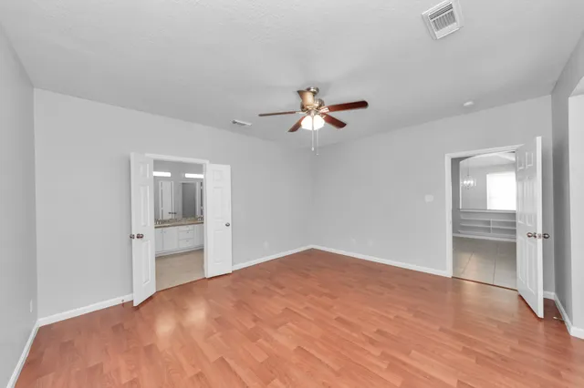 a view of a livingroom with a ceiling fan & entryway