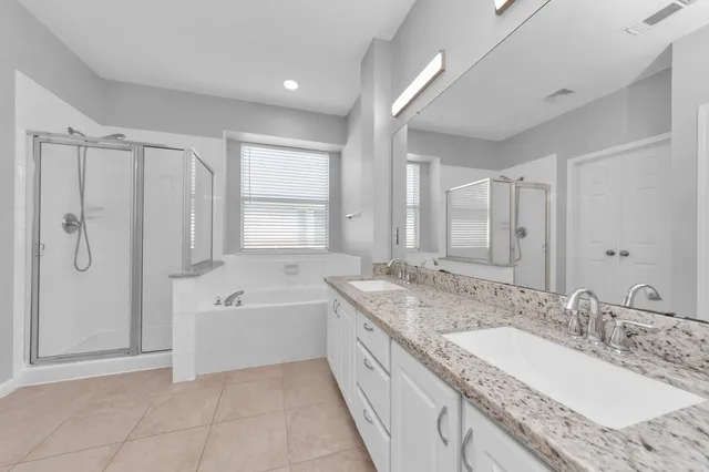 a spacious bathroom with a granite countertop tub sink and mirror