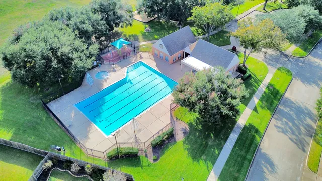 an aerial view of a house with a garden and swimming pool