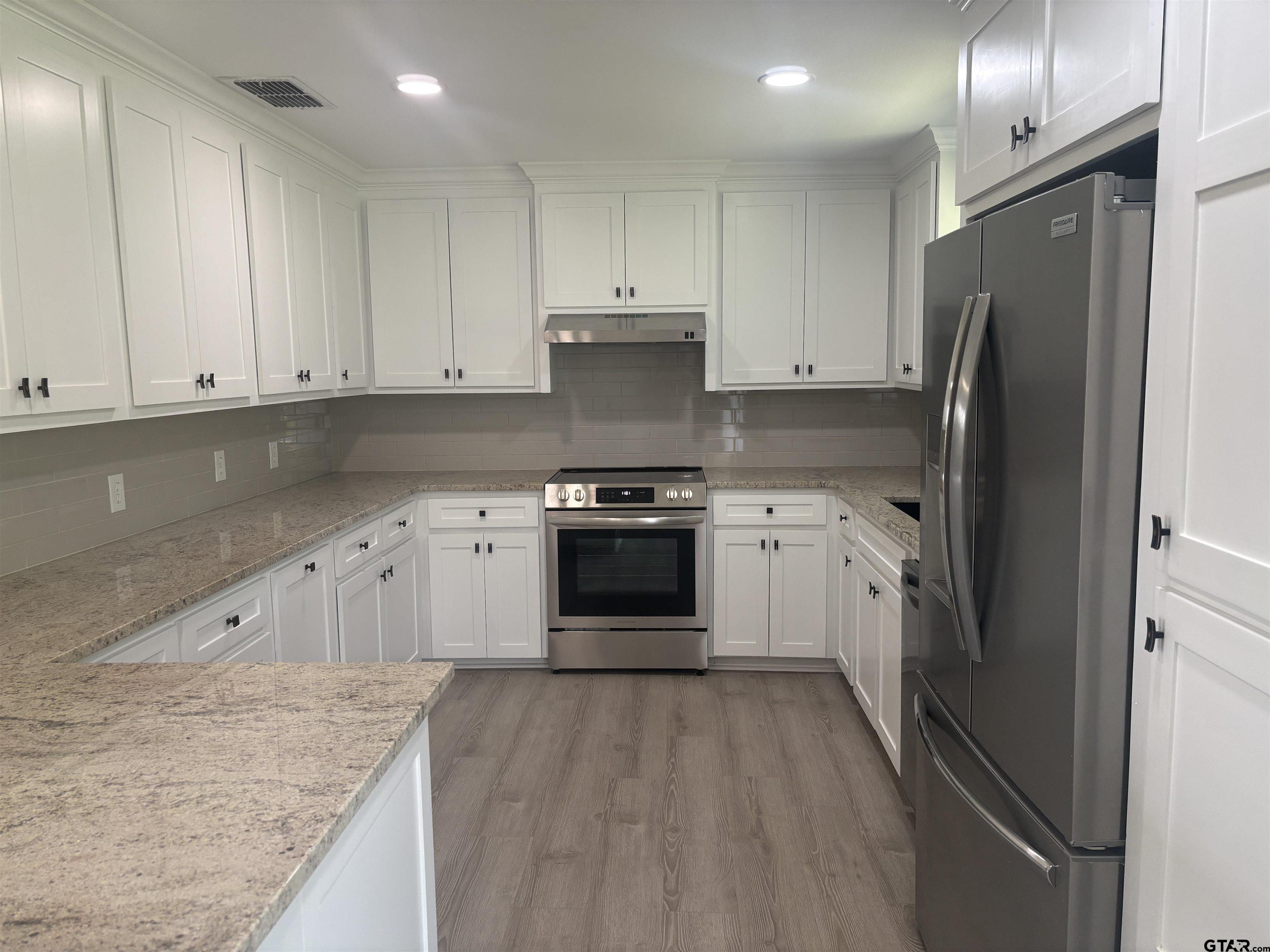 6282 Fm 2245 Pittsburg, TX 75686 - Photo 5 of 13 a kitchen with granite countertop white cabinets and stainless steel appliances