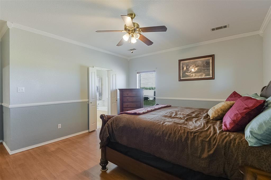 2403 Greathouse Road Waxahachie, TX 75167 - Photo 14 of 34 a bedroom with a bed and a chandelier