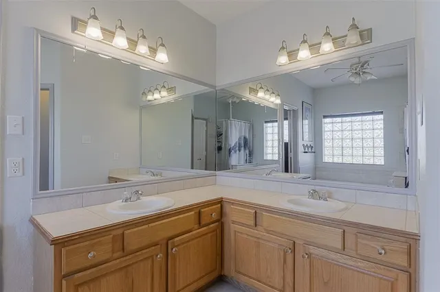 a bathroom with a sink double vanity granite and a mirror