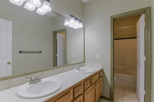 a bathroom with a granite countertop sink a light fixture and a mirror