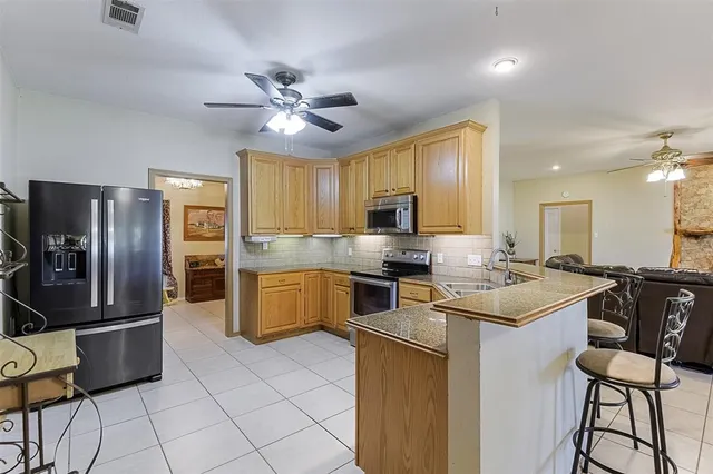 a kitchen with stainless steel appliances a stove refrigerator sink and cabinets