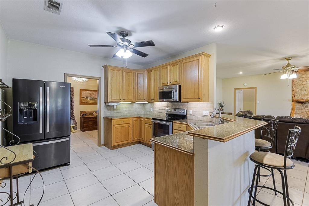 2403 Greathouse Road Waxahachie, TX 75167 - Photo 10 of 34 a kitchen with stainless steel appliances a stove refrigerator sink and cabinets