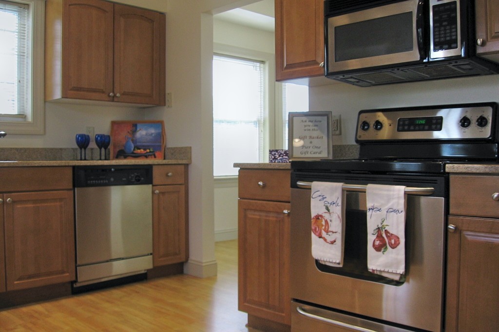1 Abbott Lane, Unit 7 Concord, MA 01742 - Photo 2 of 10 a kitchen with stainless steel appliances granite countertop a refrigerator and a stove top oven