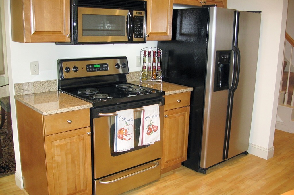 1 Abbott Lane, Unit 7 Concord, MA 01742 - Photo 3 of 10 a kitchen with stainless steel appliances granite countertop a refrigerator and a stove