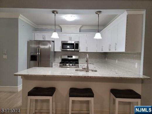 10 Lower Notch Road, Unit 15 Woodland Park, NJ 07424 - Photo 3 of 18 a kitchen with kitchen island white cabinets and stainless steel appliances