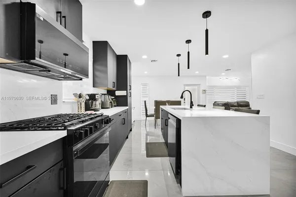 a kitchen with stainless steel appliances a stove microwave and sink