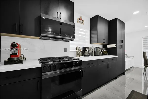 a kitchen with stainless steel appliances kitchen island granite countertop a refrigerator and a stove top oven