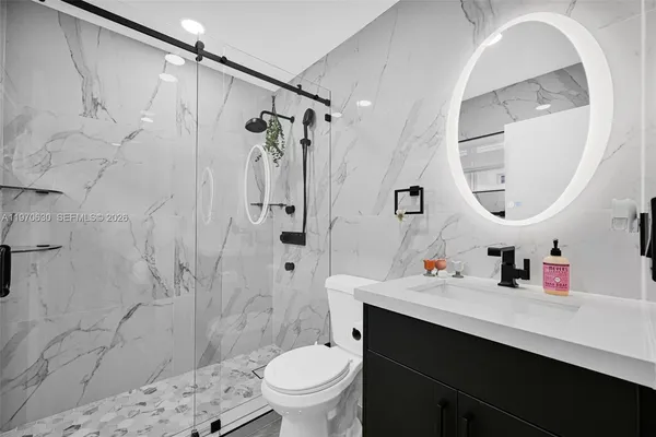 a bathroom with a sink mirror vanity and toilet