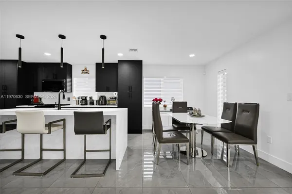 a dining room with furniture and a kitchen view